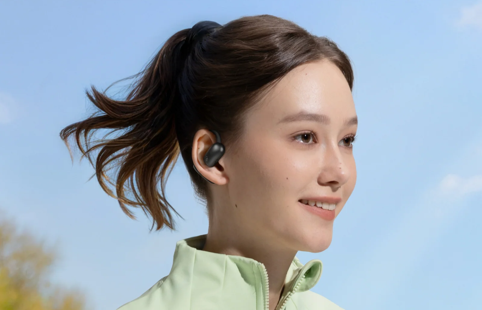 A woman wearing soundcore AeroFit 2 open ear headphone while running